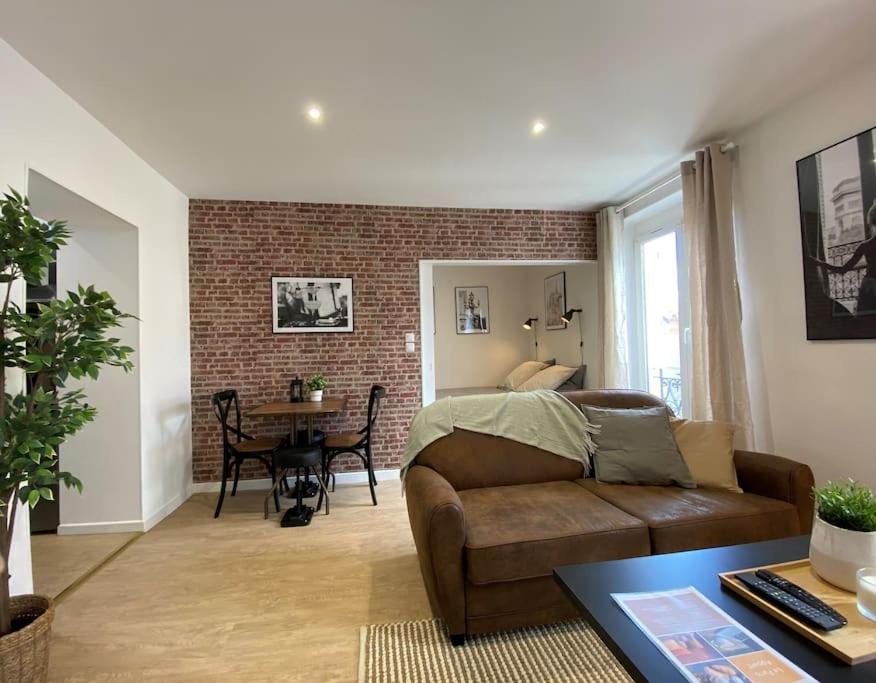 een woonkamer met een bank en een tafel bij Le Paris Appart' T2 au centre du Mans in Le Mans
