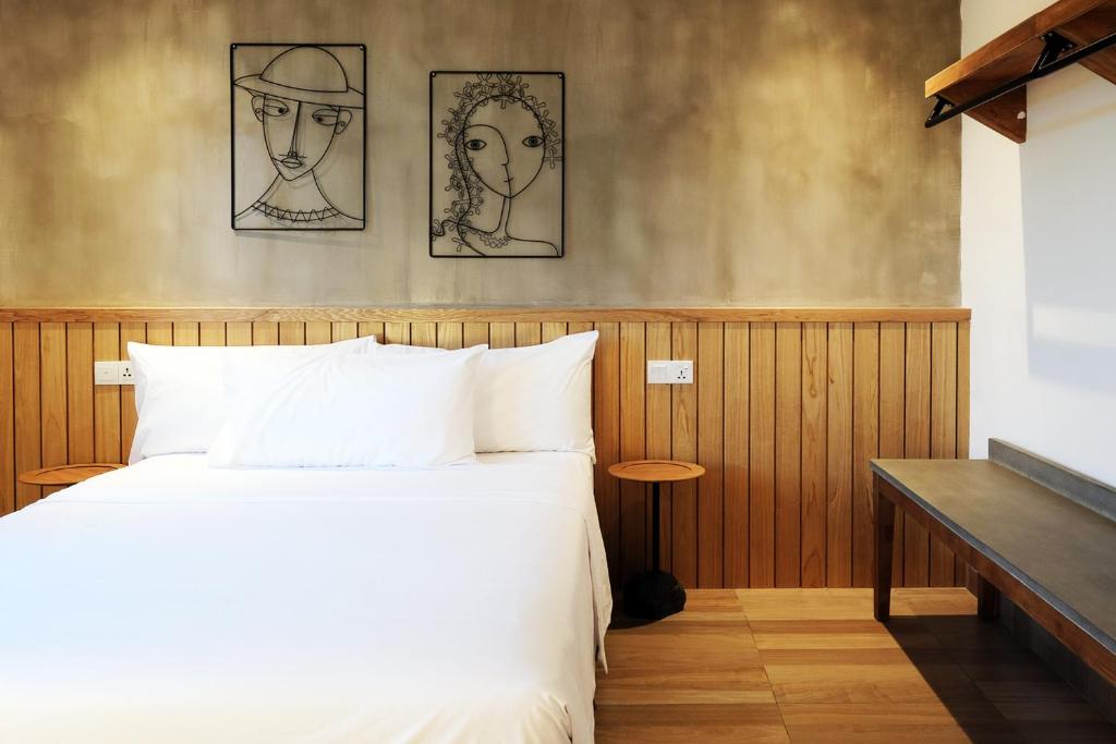a bedroom with a bed and two drawings on the wall at The Bayou Hotel Langkawi in Pantai Cenang