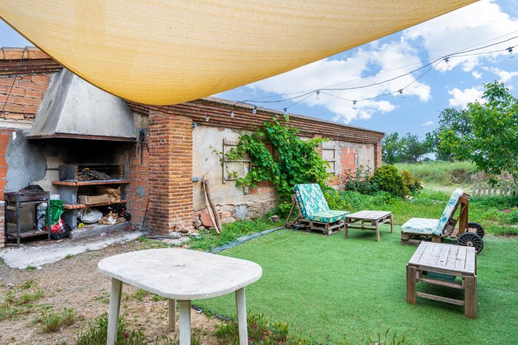 a backyard with two chairs and a table and a fireplace at Mas Guineu in Reus