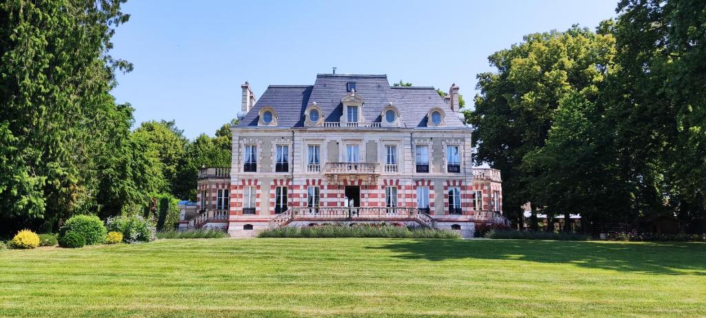 una casa grande en un campo de césped con árboles en Château de Saint Germain du Plain 