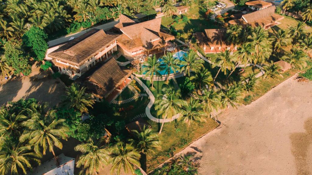 einem Luftblick auf ein Haus mit einem Pool und Palmen in der Unterkunft Costa Celine Beach Resort in Kinablañgan