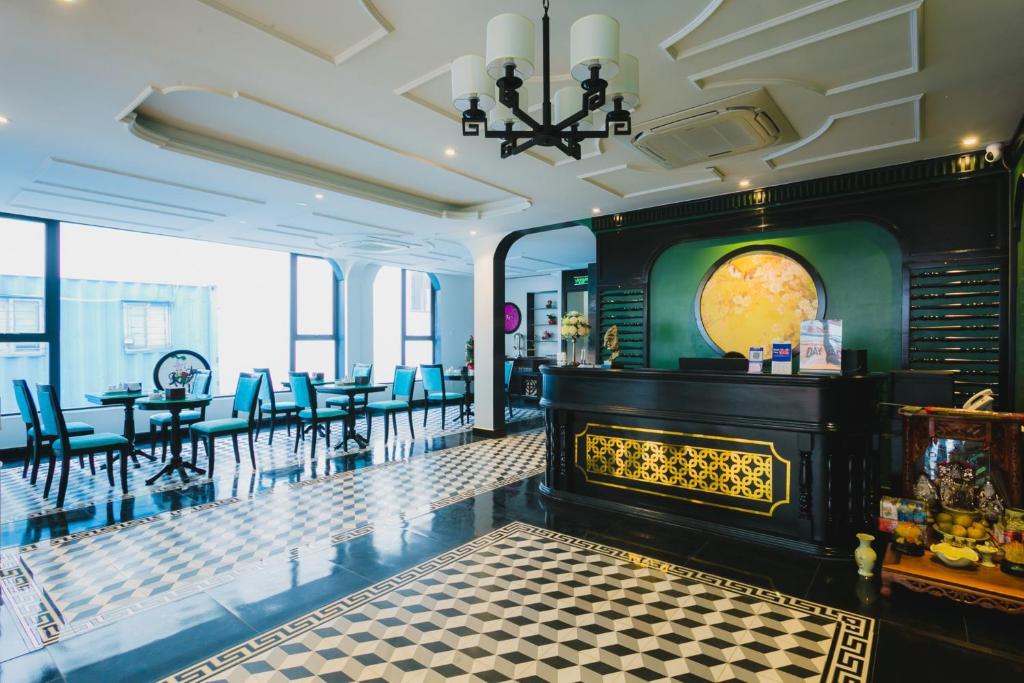 a lobby with a fireplace and tables and chairs at The Opera Hotel Hải Phòng in Hai Phong