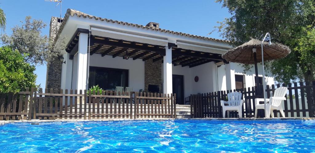 une villa avec une piscine en face d'une maison dans l'établissement VILLA LA MARISMA, à Chiclana de la Frontera