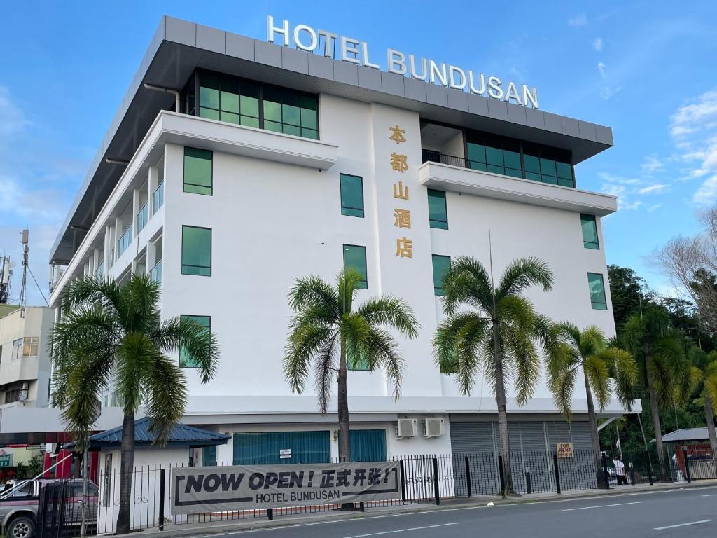 um edifício de hotel com palmeiras em frente em Hotel Bundusan em Kota Kinabalu