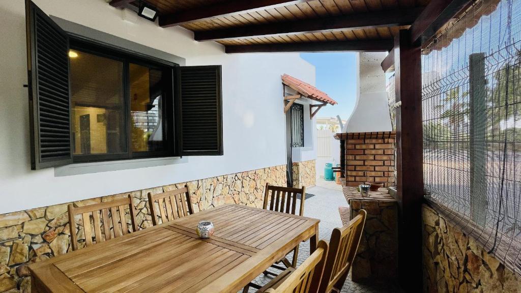 a wooden table and chairs on a patio at Neridas Villa - Near the beach - 10 Pax - Quarteira in Quarteira