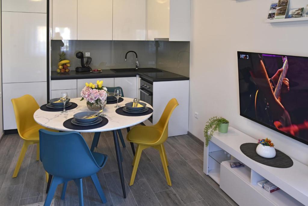 a kitchen with a table and chairs and a tv at Apartman Badi in Dugopolje