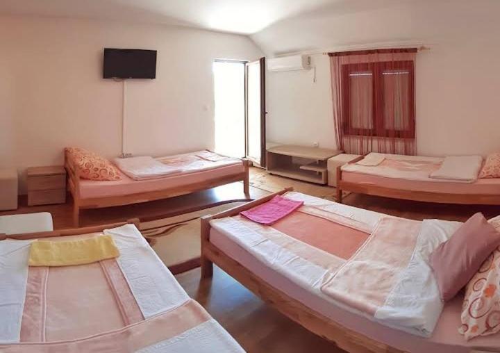 een kamer met 3 bedden en een flatscreen-tv bij S Kilaći in Mostar