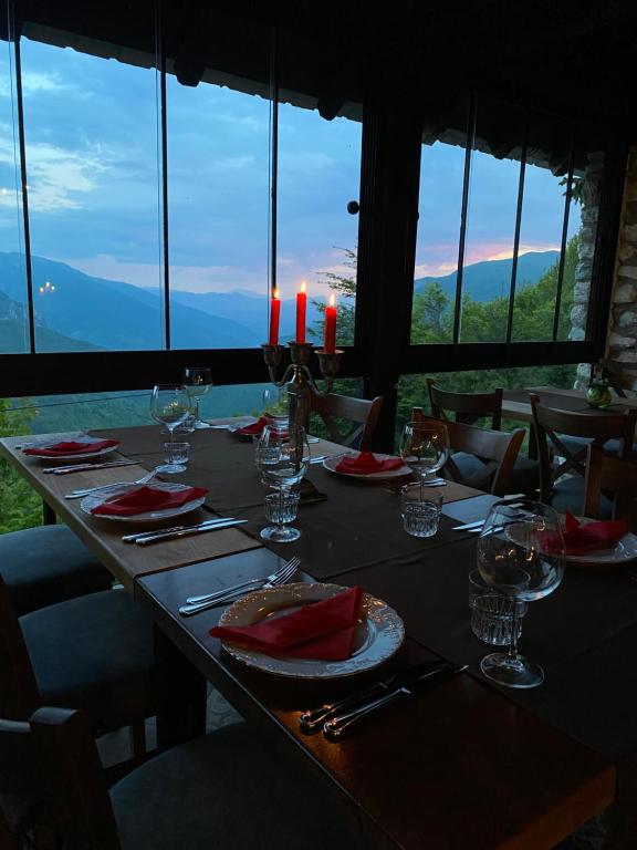 a table with glasses and candles on a table with a view at Hotel Neda Galichnik in Galičnik