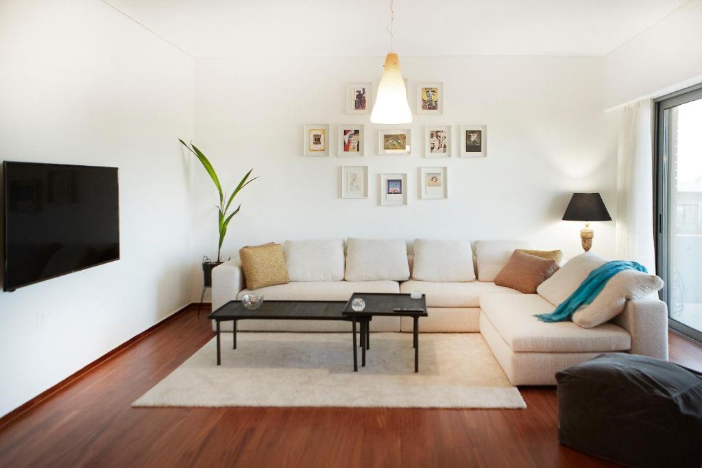 ein weißes Wohnzimmer mit einem Sofa und einem Tisch in der Unterkunft Luxury Apartment with Exceptional View in Athen