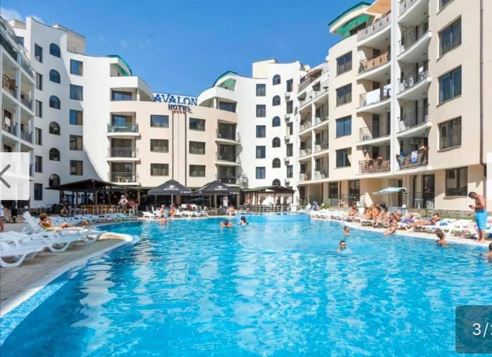 ein Schwimmbad in einem Resort mit Menschen darin in der Unterkunft AVALON, Apartment C102 in Sonnenstrand