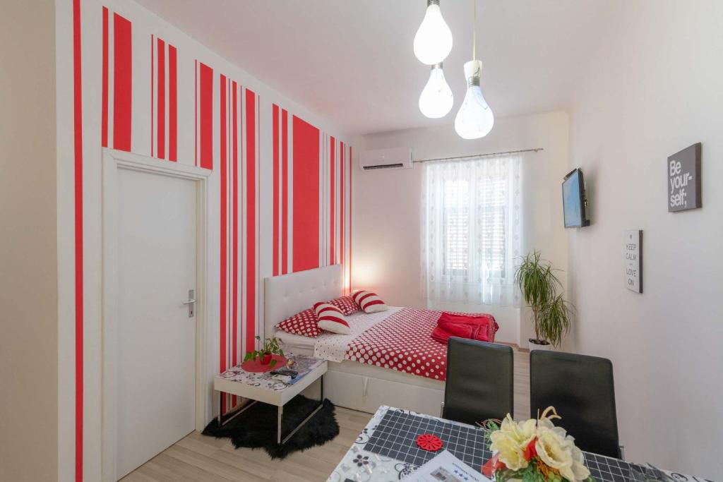 a bedroom with a red and white striped wall at Apartments Trend in Rijeka