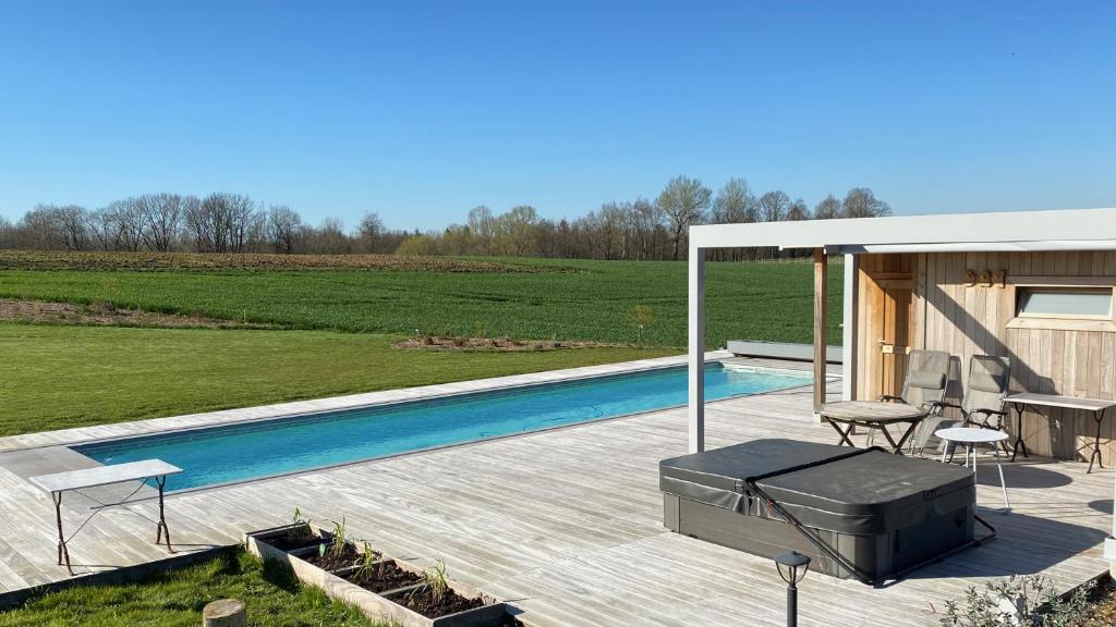 een achtertuin met een zwembad en een huis bij B&B Les Autres Sens in Villers-la-Ville