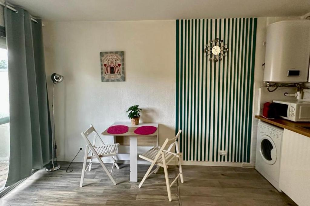 une cuisine avec une table et des chaises dans une pièce dans l'établissement Bright studio with balcony at the foot of the sea, à Nice