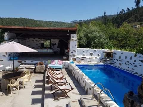 a resort with a swimming pool and a table and chairs at A Cancela House Arouca Paiva Walkways in Lázaro