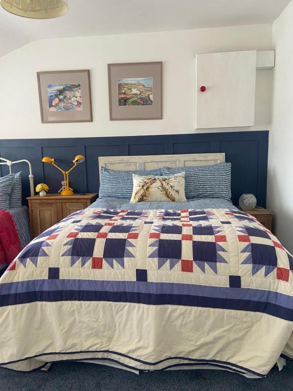 a bed with a blue and white quilt on it at Barrow Harbour studio apartment in Tralee