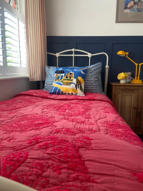 a bed with a red comforter in a bedroom at Barrow Harbour studio apartment in Tralee