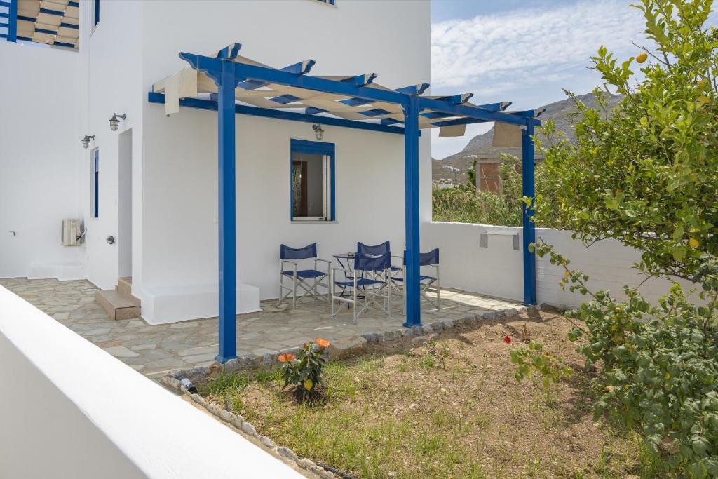 a patio with blue posts and chairs on a white house at Studios Ninemia Serifos 3 in Livadi