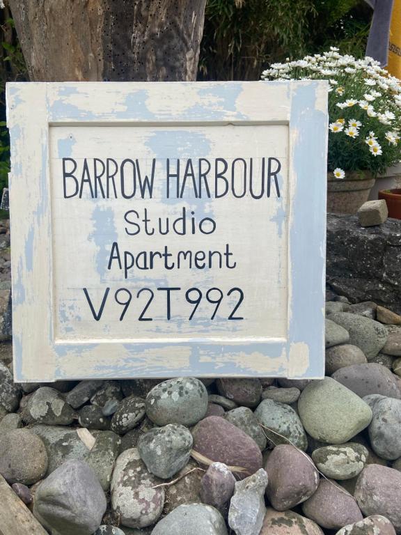 a sign sitting on a pile of rocks at Barrow Harbour studio apartment in Tralee