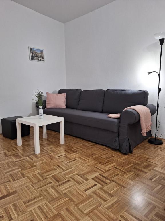 a living room with a blue couch and a table at Apartment Kp with parking in Koper