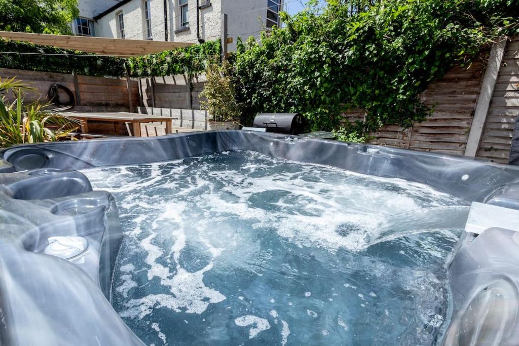 a hot tub with water in it in a backyard at 4 The Old Schoolhouse: Parking, hot tub, garden, air con in Whitstable