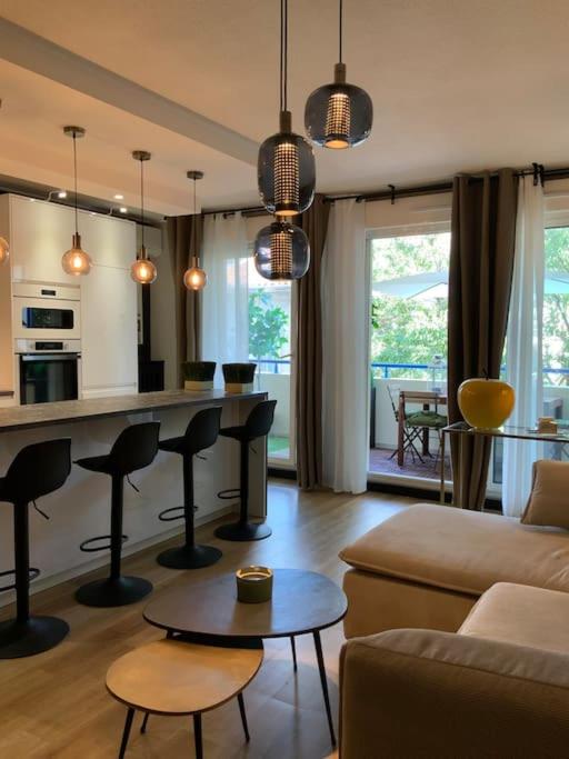 un salon avec un canapé et une cuisine avec un bar dans l'établissement L’élégance du prado, à Marseille