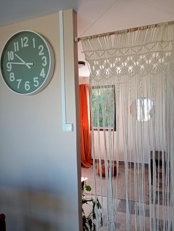 a clock hanging on a wall next to a room at Couleur pastel in Saint-Louis