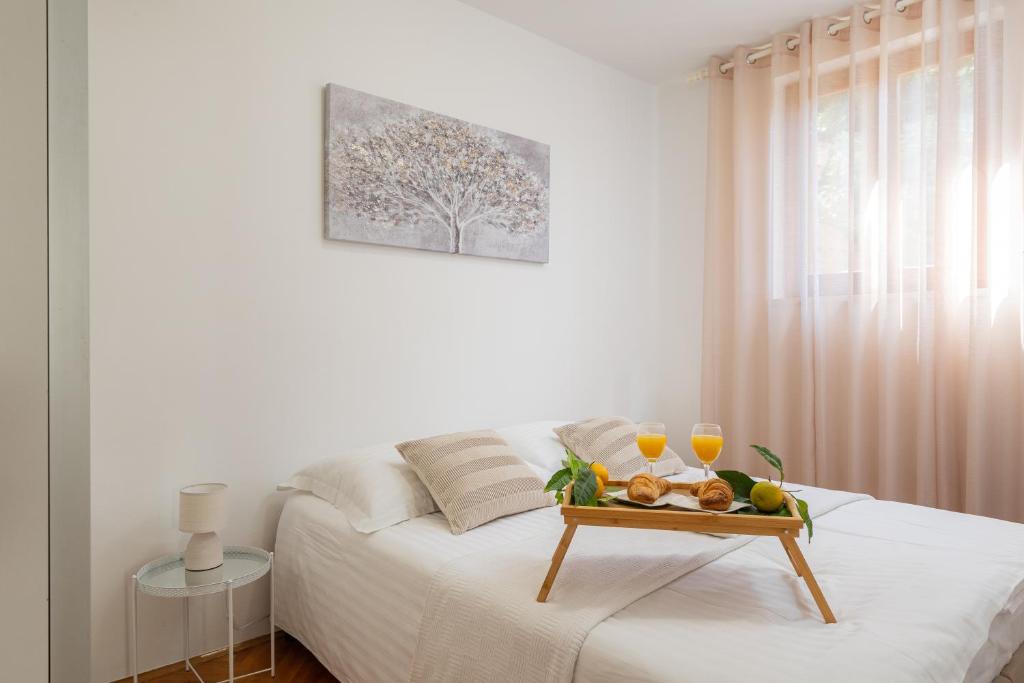 een dienblad met fruit en wijnglazen op een bed bij Garden Vista apartment in Dubrovnik