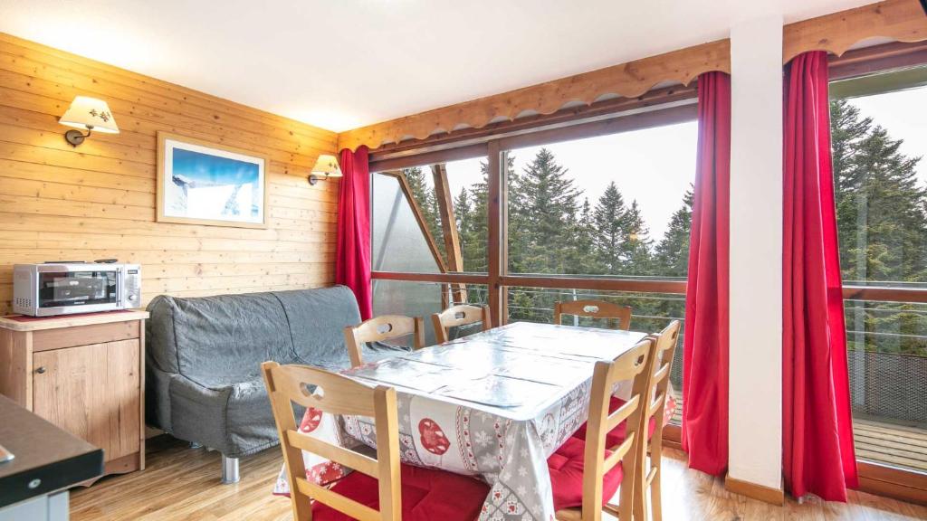 a dining room with a table and a window at V du Bachat Asters B21 - Appt 6 pers in Chamrousse