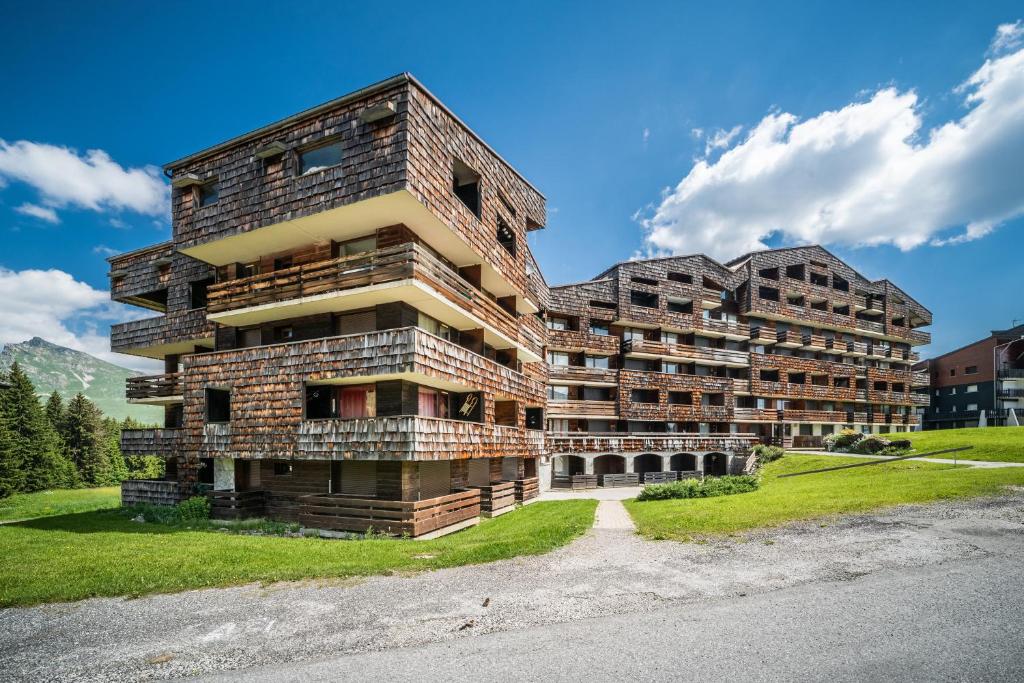 an apartment building in the mountains next to a road at Les Pralyssimes in Taninges