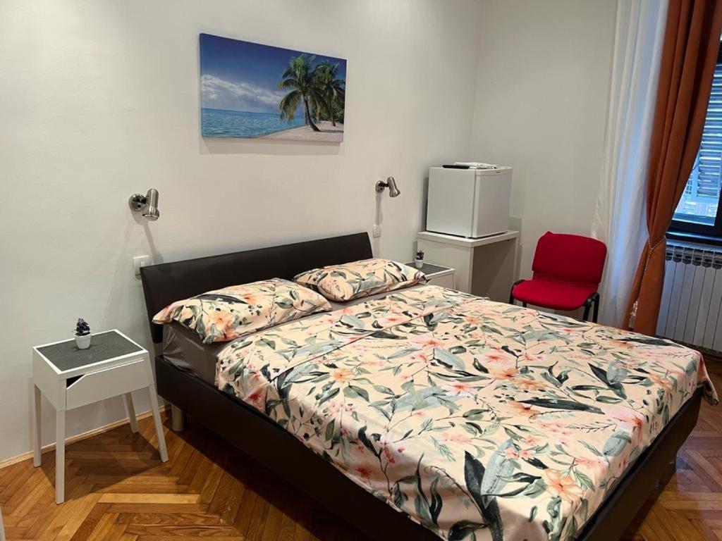 a bedroom with a bed and a red chair at Rooms Aida in Pula