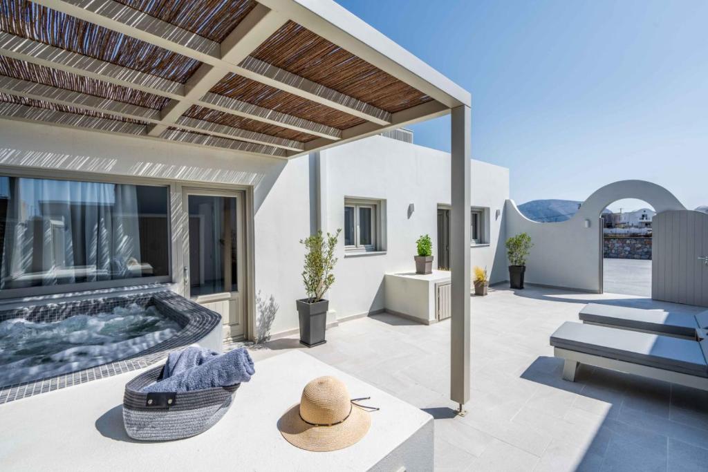 un patio al aire libre con chimenea y silla en New Sea Serenity Villas Next to the Sea With Private Jacuzzi, en Vlychada