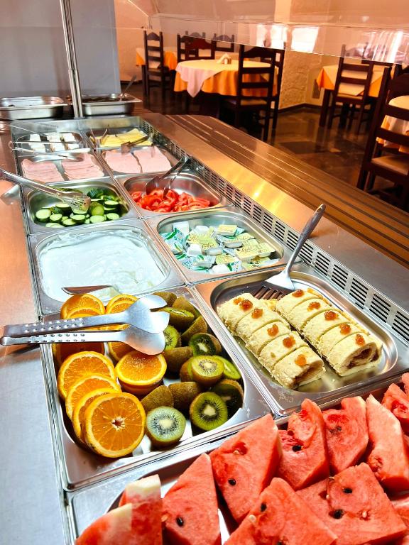 a buffet with many trays of different types of food at Karteros Hotel in Karteros