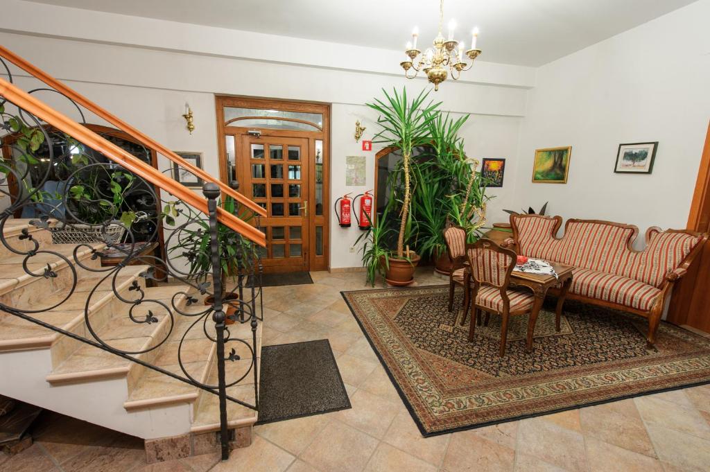 a living room with a staircase and some plants at Hotel Sporn in Radomlje