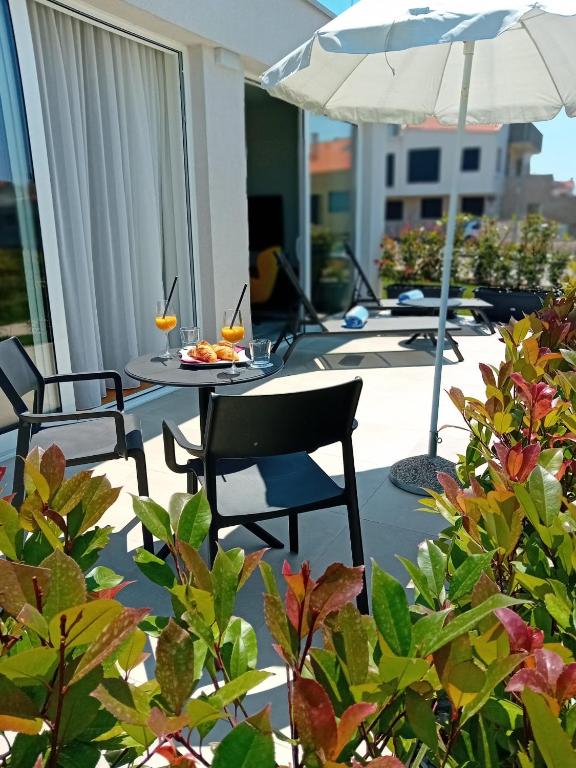 a patio with a table and chairs and an umbrella at Maj Luxury Residence in Poreč