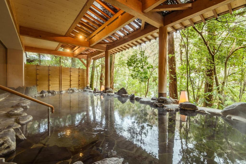a pool of water in a house with a wooden ceiling at Shirasagiyu Tawaraya in Kaga
