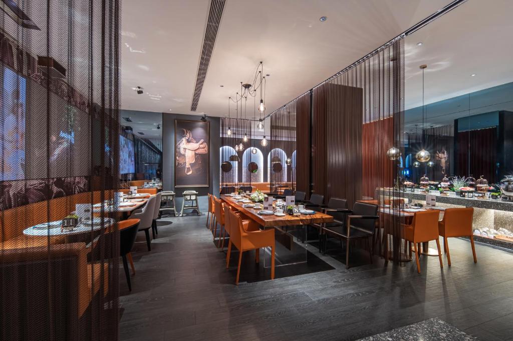 een restaurant met tafels en stoelen en een bar bij Arthur Hotel Zhujiang New Town Guangzhou in Guangzhou