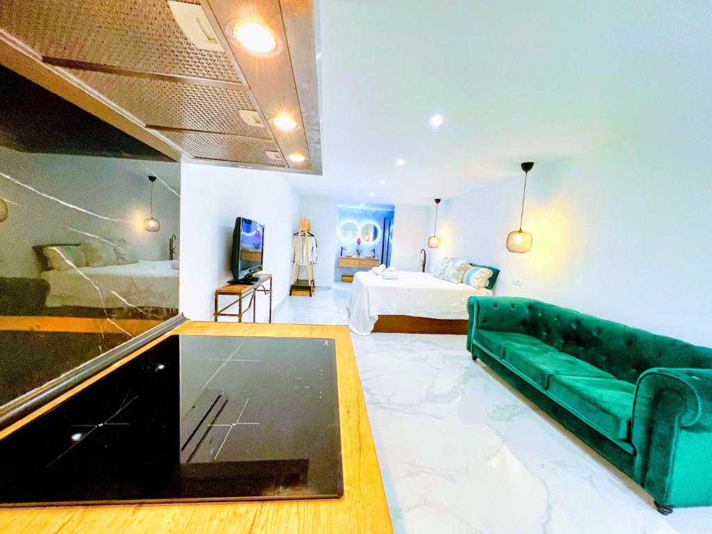 sala de estar con sofá verde y cama en Garden Boutique, en Mijas Costa