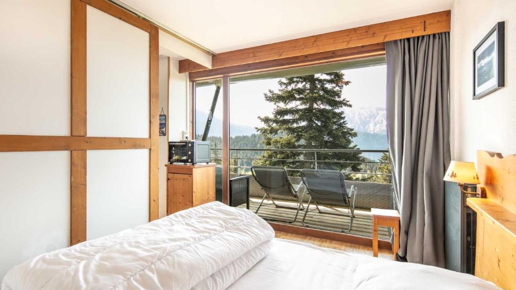 une chambre avec un lit et une grande fenêtre dans l'établissement V du Bachat Sorbiers E32 - Appt 6 pers, à Chamrousse