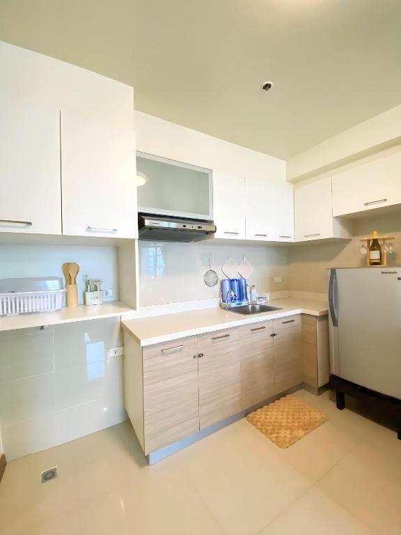 uma cozinha com armários brancos e um frigorífico em Adah's Place em Manila