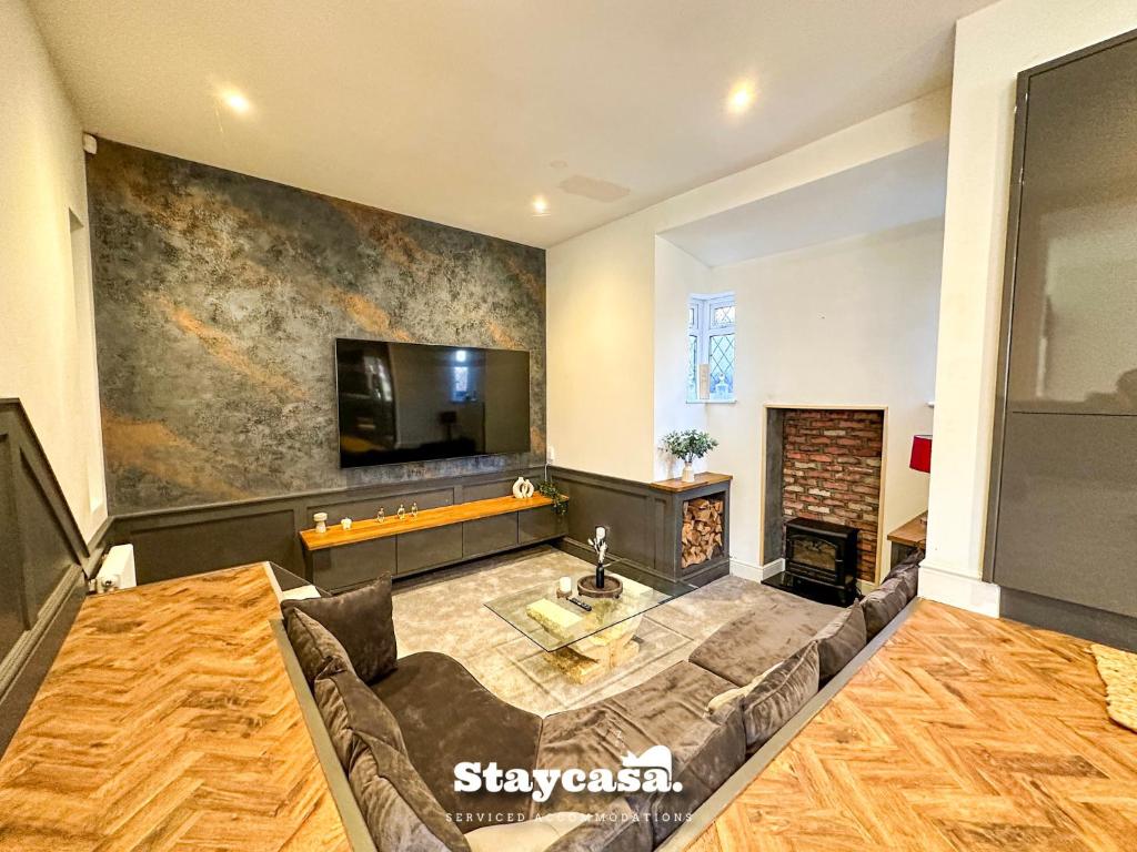 a living room with a couch and a tv at Beautiful Detached Villa - Jacuzzi Bath - Parking in Manchester