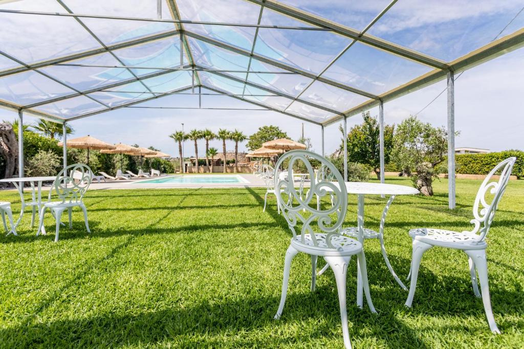 un gruppo di sedie e un tavolo sotto una tenda di Federico Holidays - Bed & Breakfast con piscina a Racale