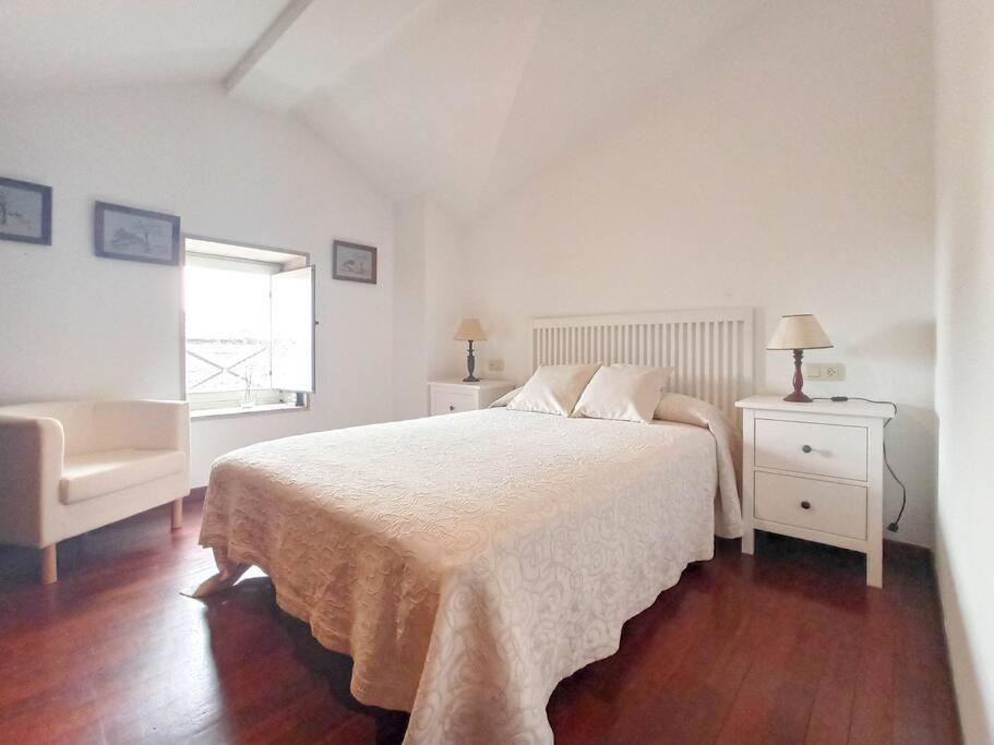 - une chambre blanche avec un lit et une fenêtre dans l'établissement Apartamento calle Real, à Cambados