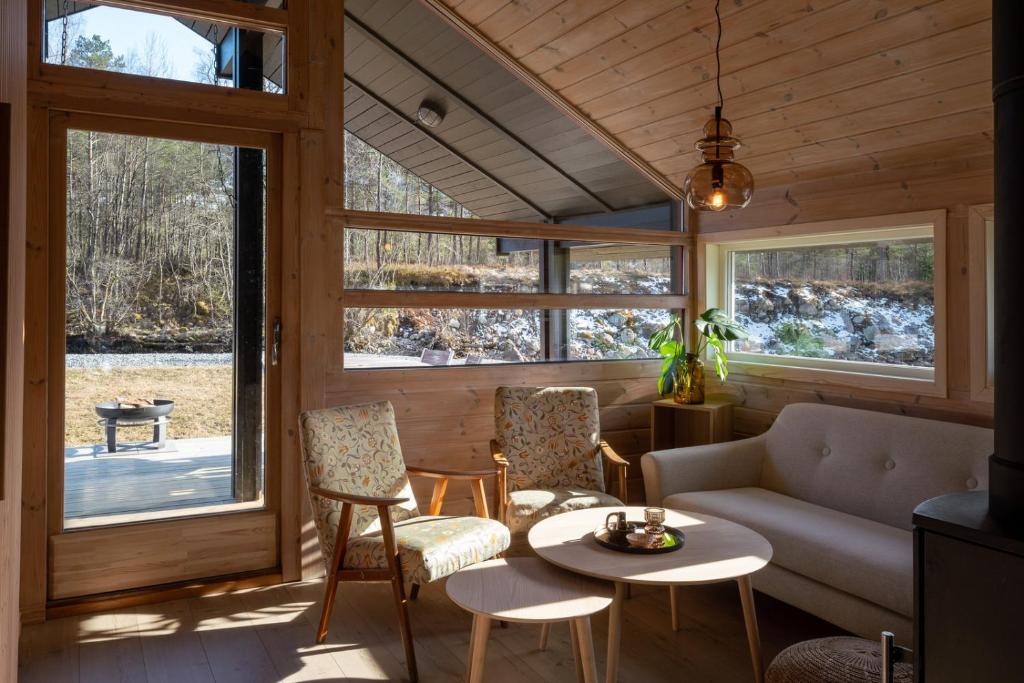 a living room with a couch and a table and chairs at Jølstraholmen Camping og Hytter in Vassenden