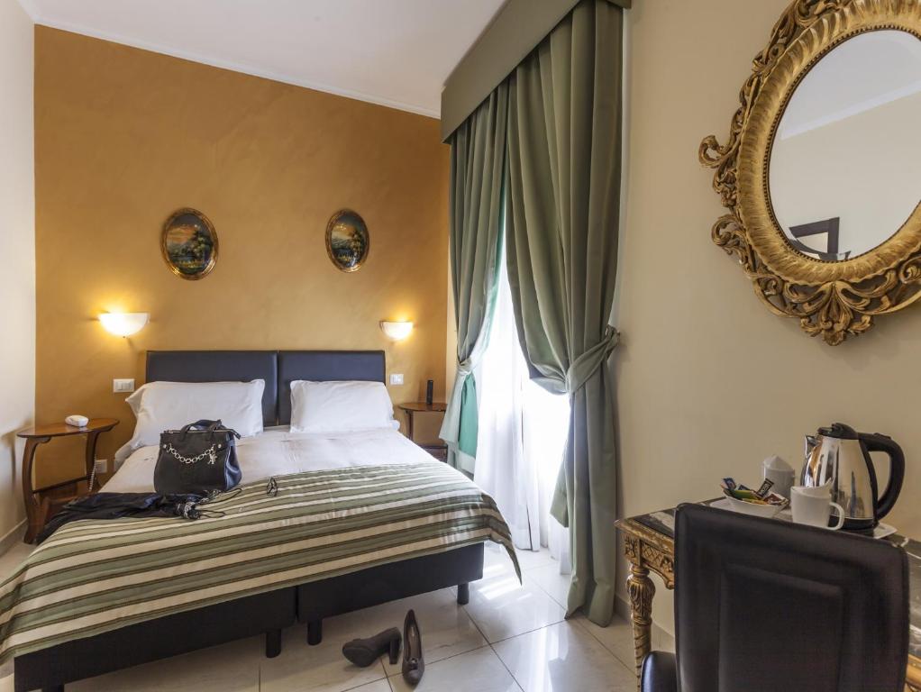 ein Schlafzimmer mit einem großen Bett und einem Spiegel in der Unterkunft Hotel Regina Giovanna in Rom