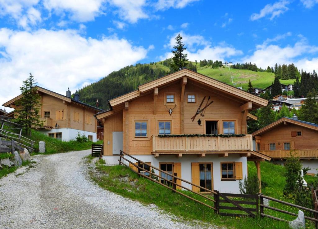 une maison avec balcon sur un chemin de terre dans l'établissement Ferienhaus Königsleiten 175, à Königsleiten