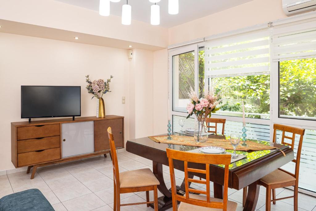 a dining room with a table and chairs and a tv at Niovi Luxury Apartment in Samos