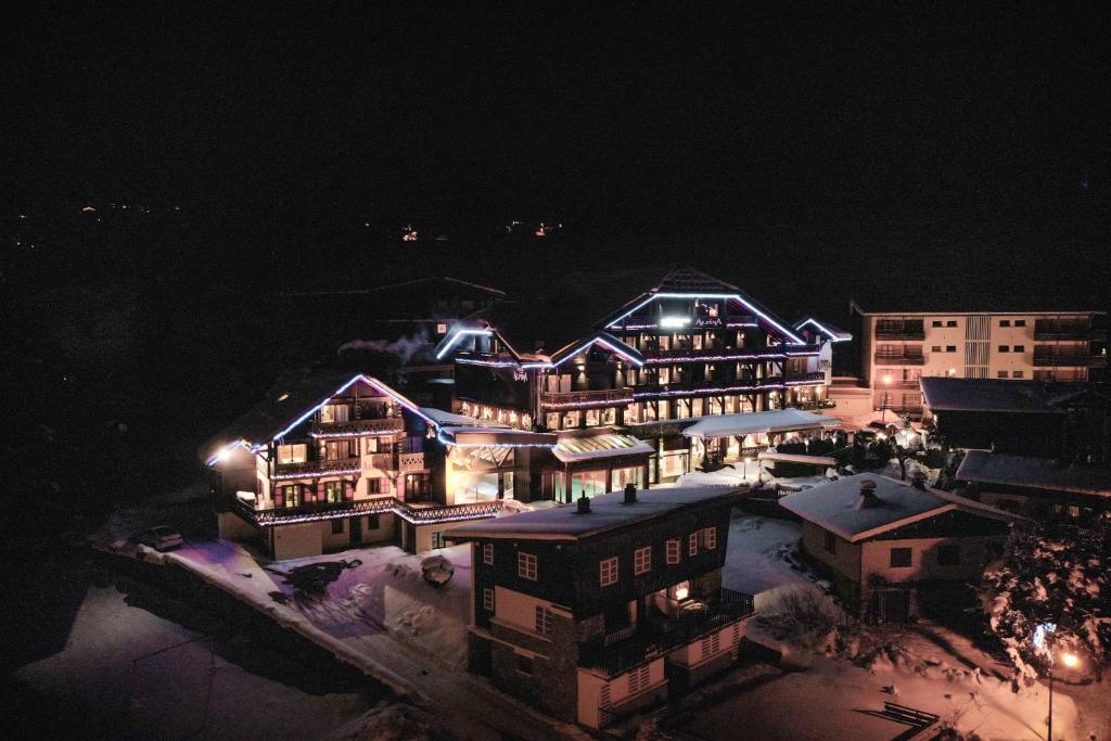 a large building is lit up at night at Hôtel Alpina &amp; SPA in Les Gets