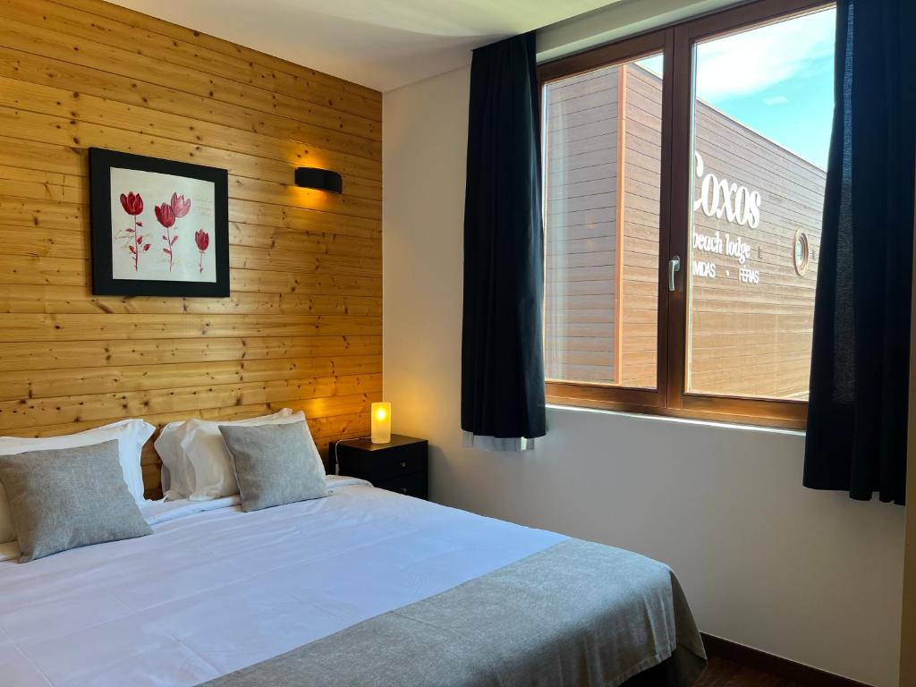 sypialnia z białym łóżkiem i oknem w obiekcie Coxos Beach Lodge w mieście Ericeira