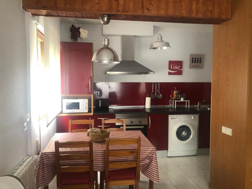 uma cozinha com uma mesa e uma cozinha com uma máquina de lavar roupa em Apartamento Torrelavega em Torrelavega