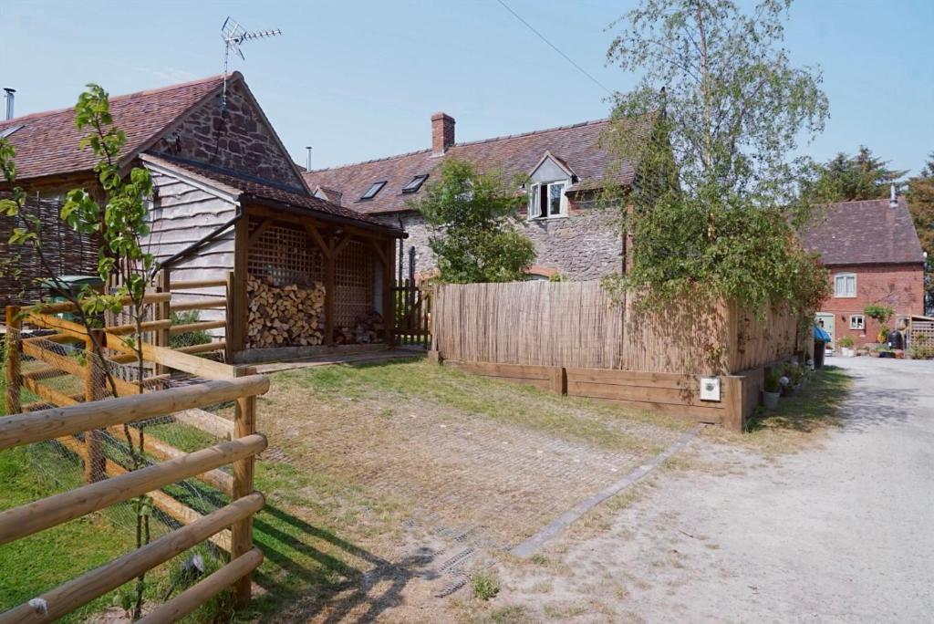 a house with a wooden fence in front of it at Nest Holiday Hideaway Dove Barn Amazing location! in Church Stretton